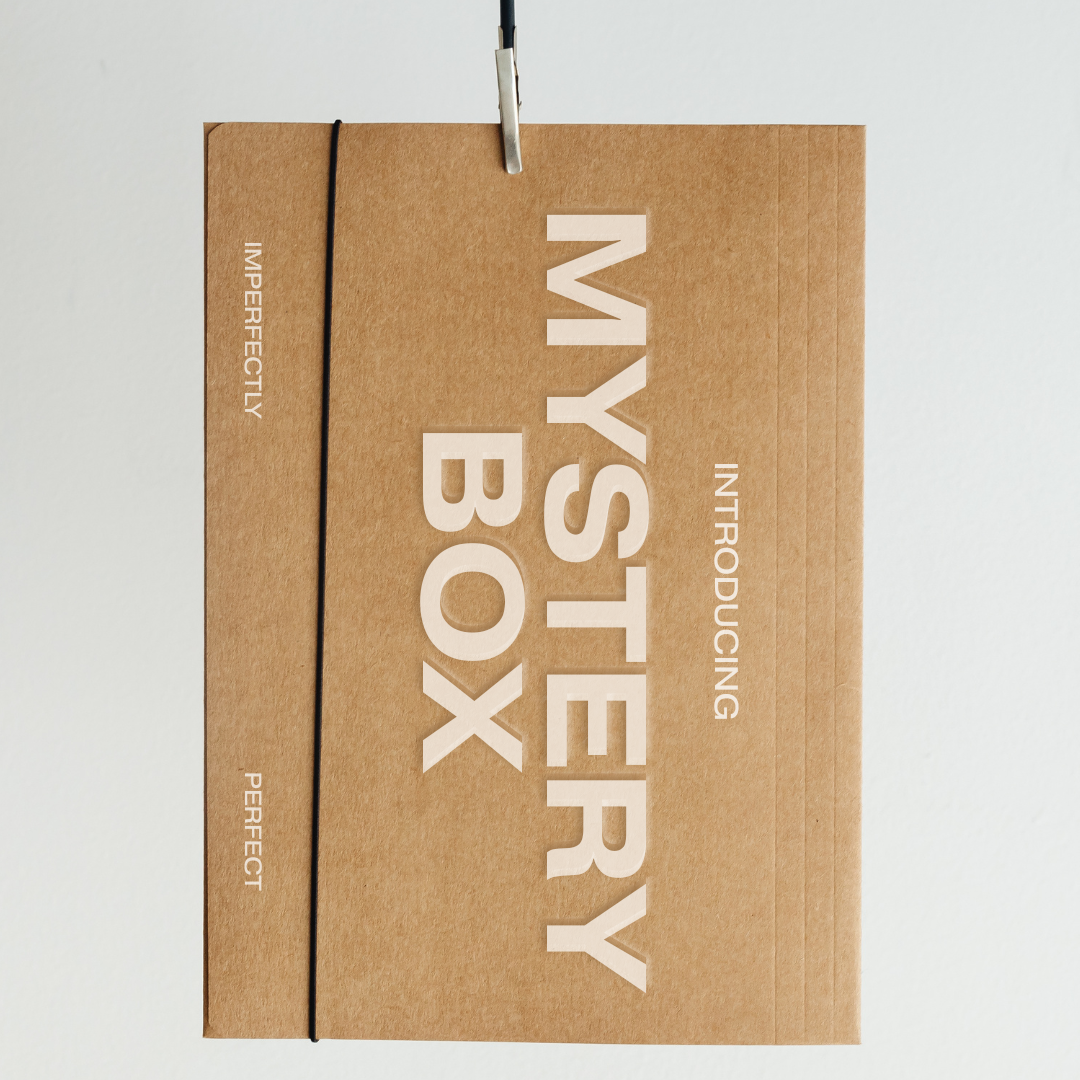 Brown cardboard box with 'Mystery Box' text on a light gray background
